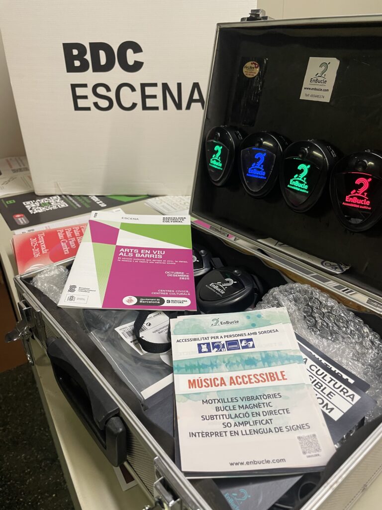 Maleta amb equips d’accessibilitat com receptors i materials informatius sobre serveis com motxilles vibratòries i bucle magnètic en un espai cultural del BDC Escena.