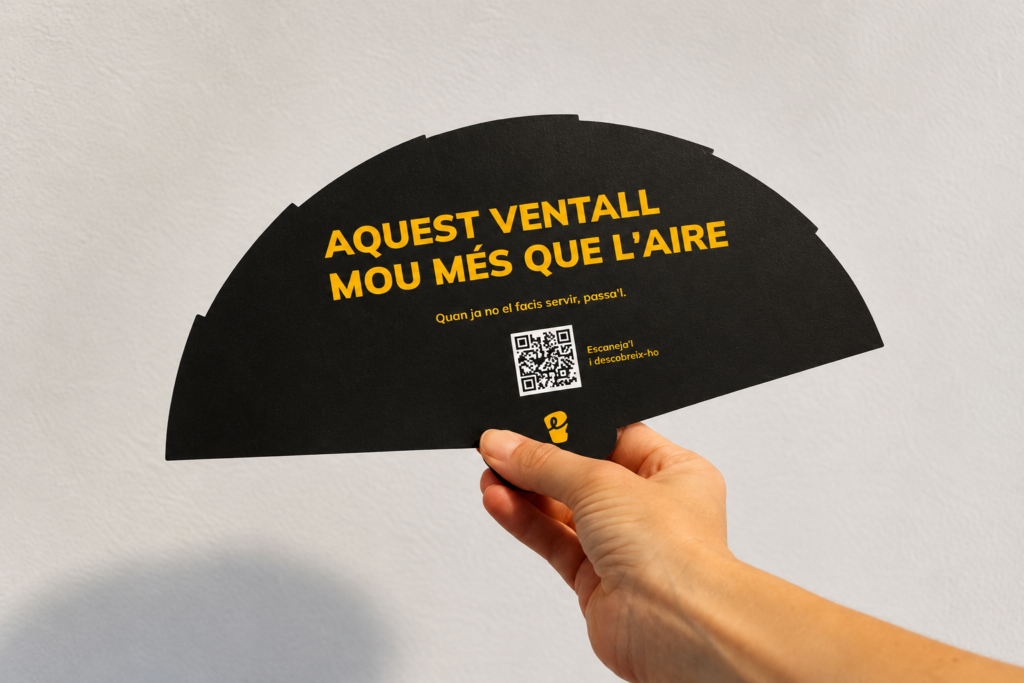 Persona sostenint un ventall negre d'EnBucle amb el missatge "Aquest ventall mou més que l'aire".